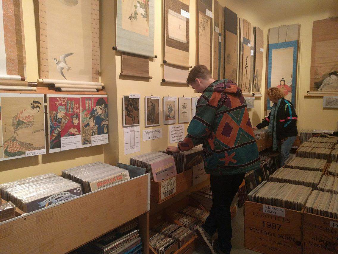 Student Jack Leiper looking through rows of records and Paradise Bound.