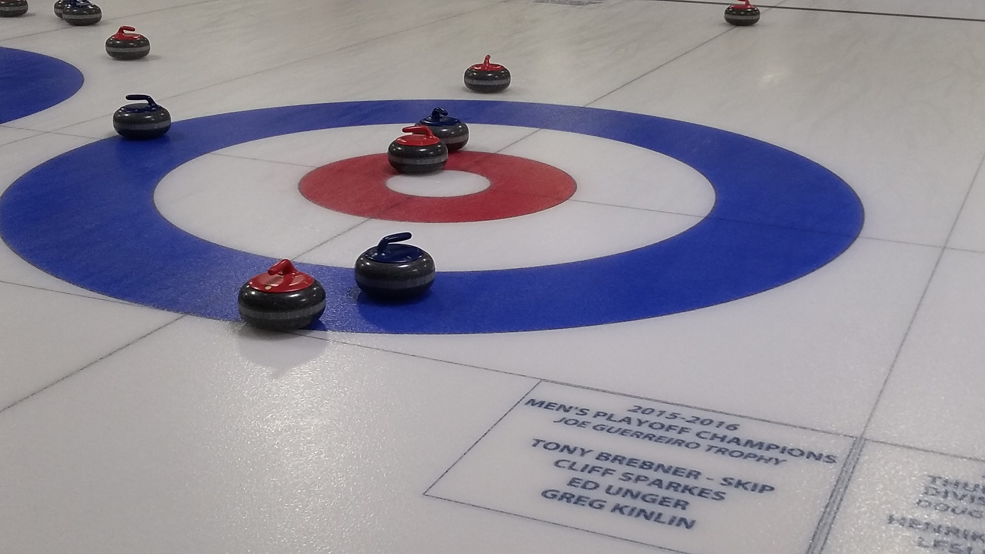 Curling rink with red and blue curling stones.