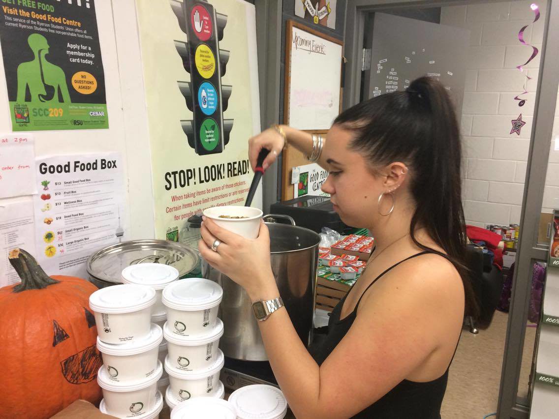 Ryerson student Claire Davis filling cups of lentil soup.