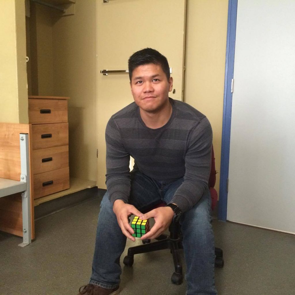 Man seated in office chair holding Rubik's cube