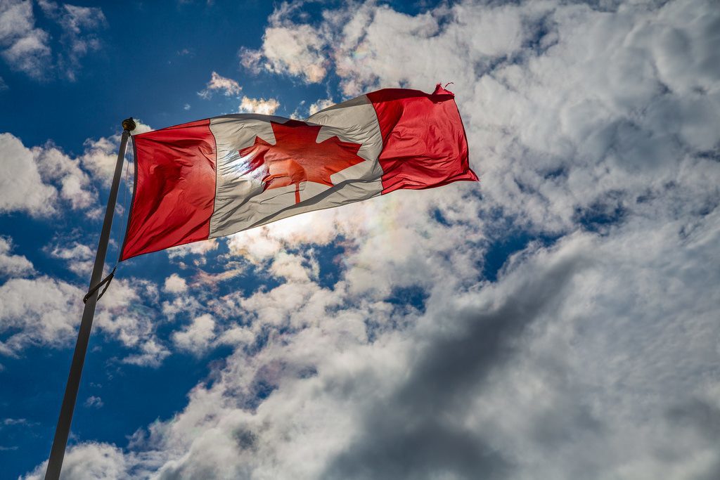 Canadian flag waving against the sky.