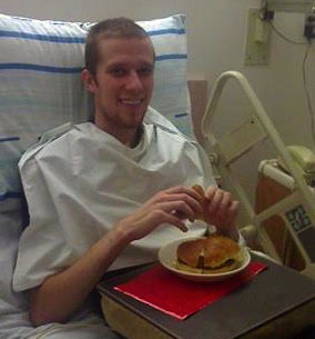 Man in hospital bed eating.