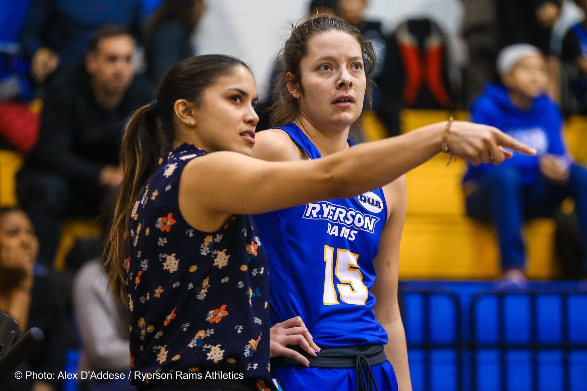 Woman speaking and pointing to woman wearing Ryerson Rams jersey
