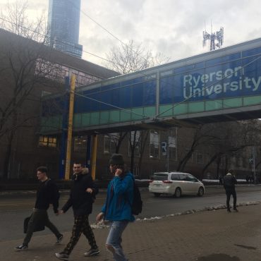 Students walk down Church street in Toronto passing under a Ryerson University walkway.