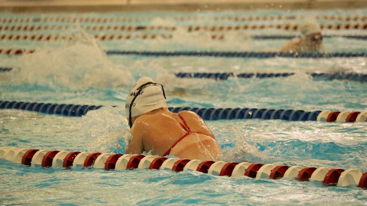 Woman swims the breast stroke in the lane in a swimming pooling