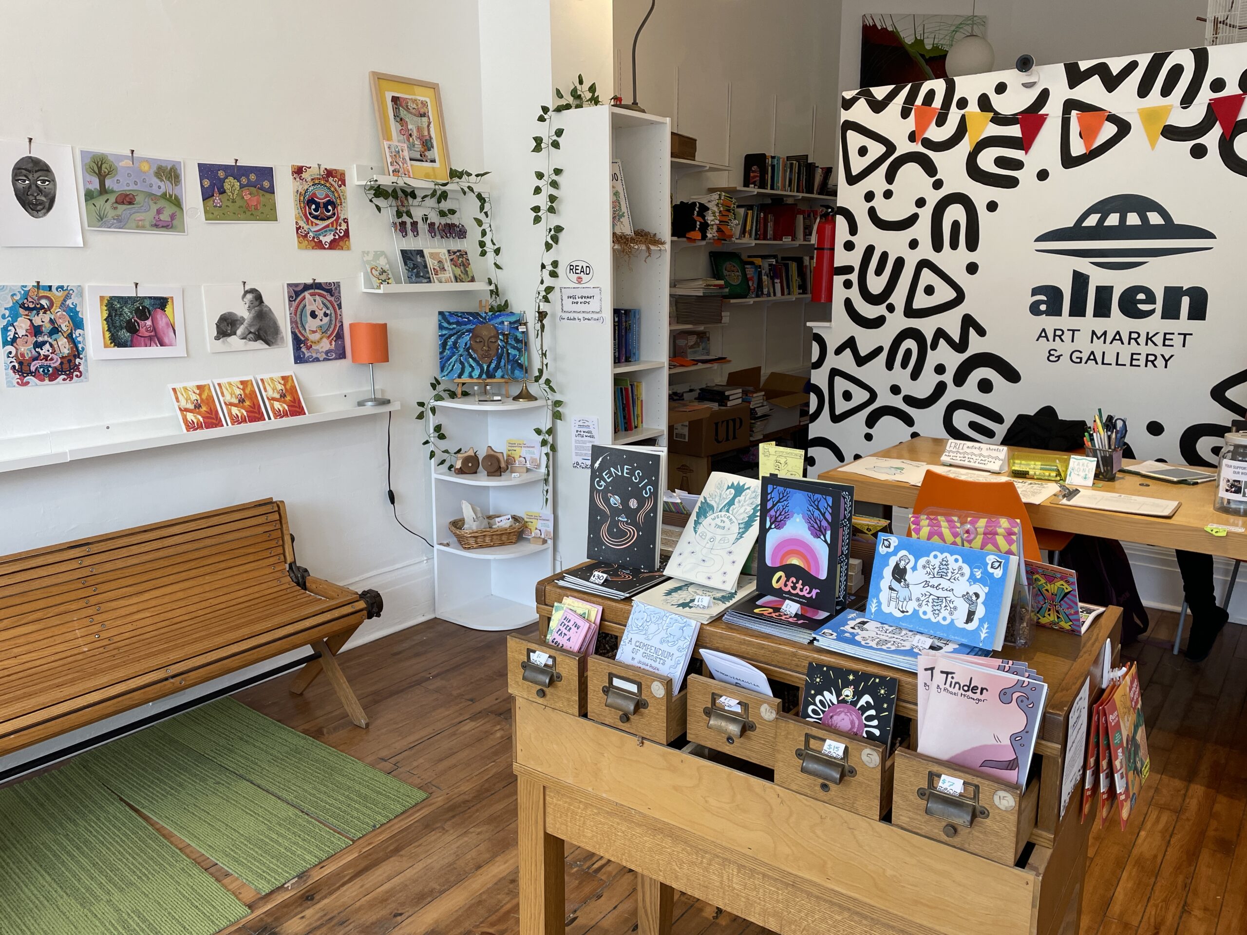 A photograph of Alien Art Market, featuring books and artwork on display on shelves.