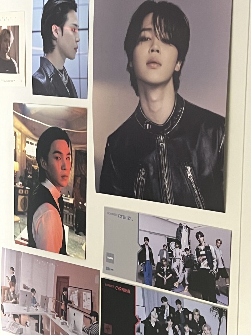 An image of seven different K-pop posters stuck to a wall. Pictured are Jimin and Suga of BTS, and group photos of K-pop group ENHYPEN. (TMUSJ/Nika Petrosian)