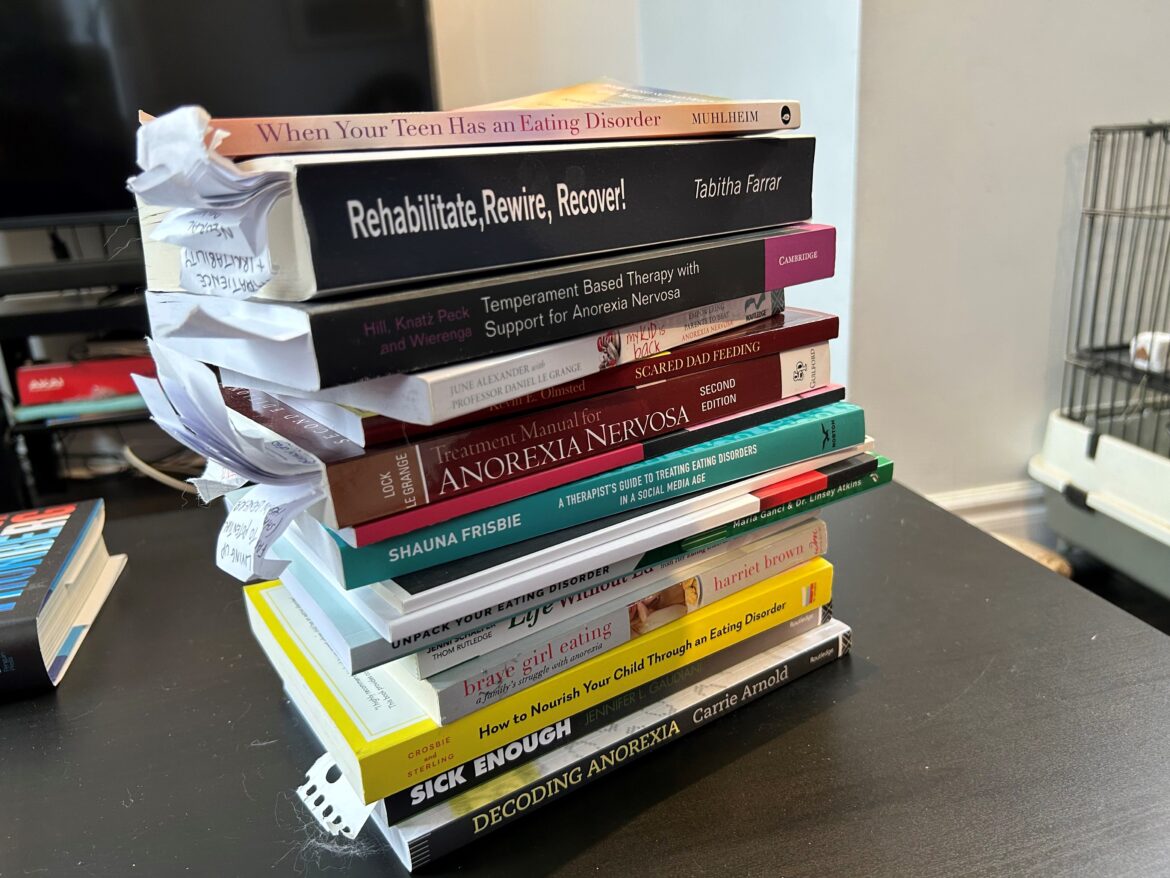 Eating disorder recovery pamplets and books stacked on top of eachother. 