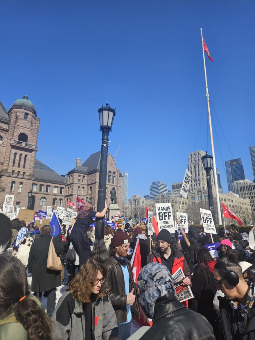 students protesting in front of brown buildings