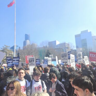 students protesting holding several signs in a big group