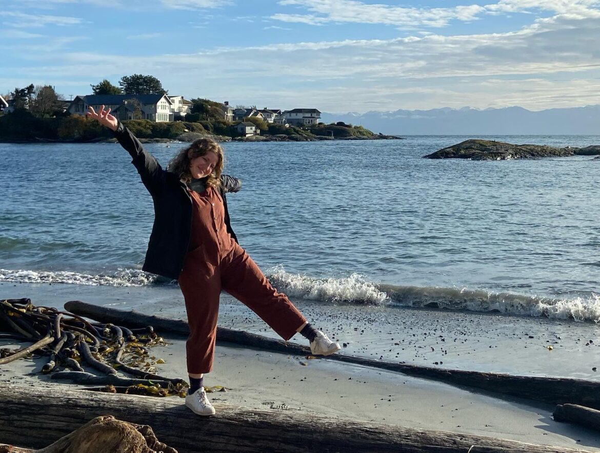 Hannah stands and poses by the beach