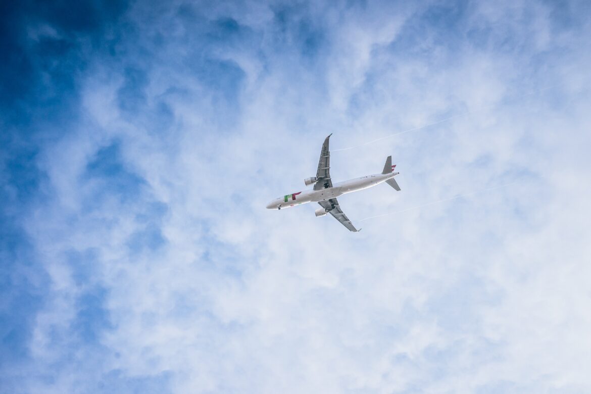 An airplane in a partially cloudy sky