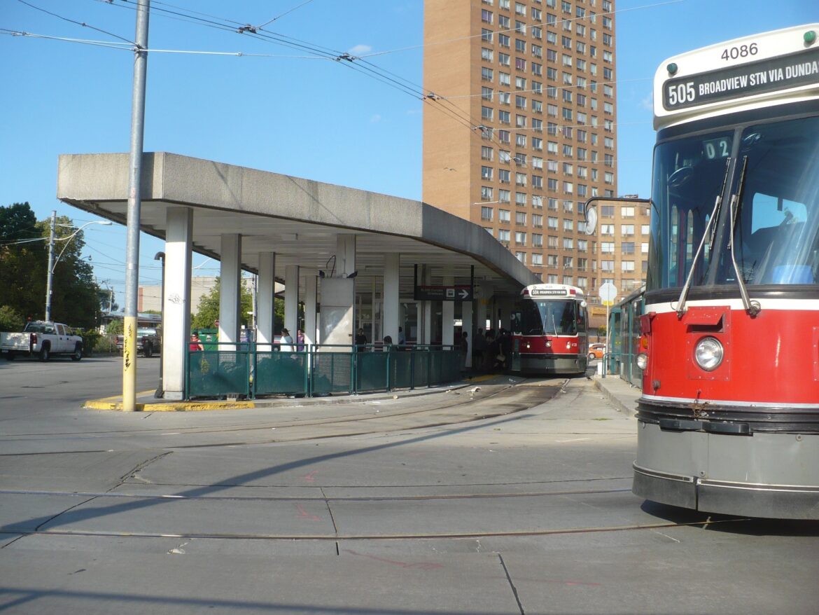 A streetcar terminal in front of a tall beige building