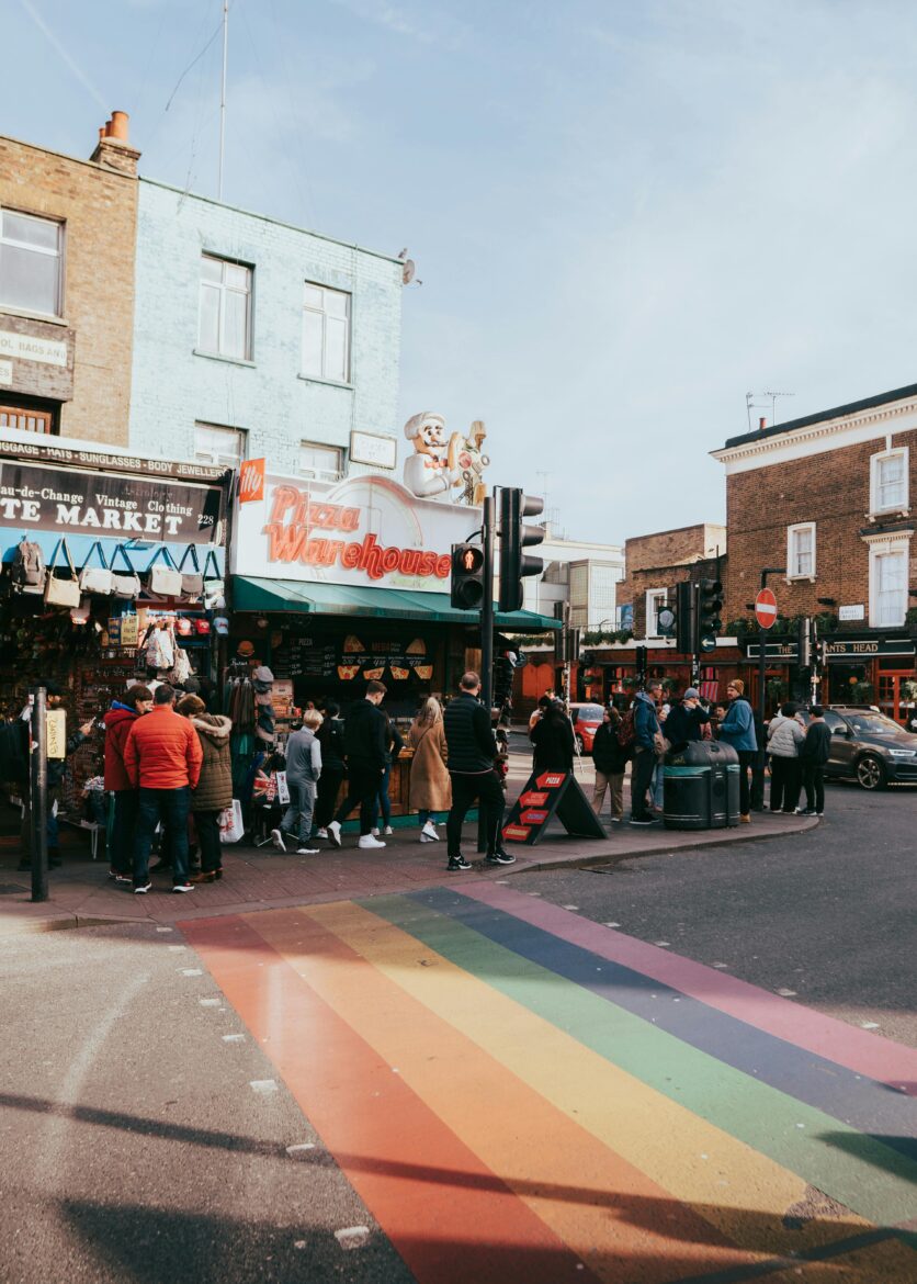 Rainbow cross walk with people on sidewalk